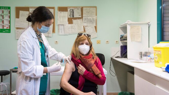 Una mujer recibe la vacuna de la gripe en un centro de salud.