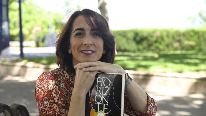 María Iglesias posa con su obra, 'Horizonte', que presenta este sábado en la Feria del Libro de Córdoba.